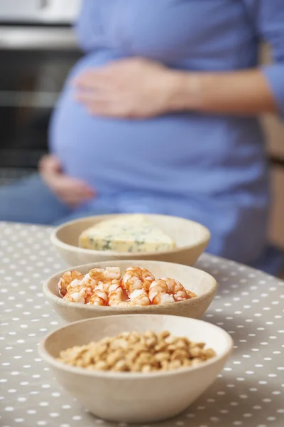 Donna incinta che guarda gli alimenti da evitare durante la gravidanza — Foto Stock