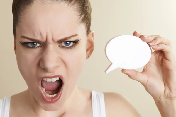 Раздражённая женщина, держащая пузырь речи и кричащая — стоковое фото