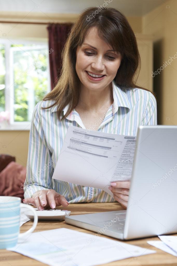 Smiling Middle Aged Woman Looking At Household Finances