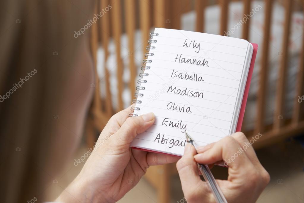 Woman Writing Possible Names For Baby Girl In Nursery