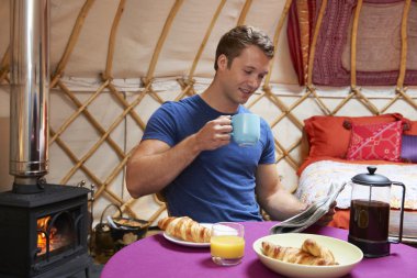 Adam geleneksel Yurt kamp ederken kahvaltı keyfi