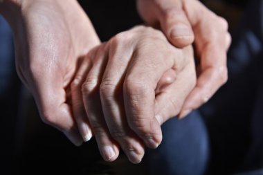 Yaşlı kadının el siyah arka planda tutan genç kadın