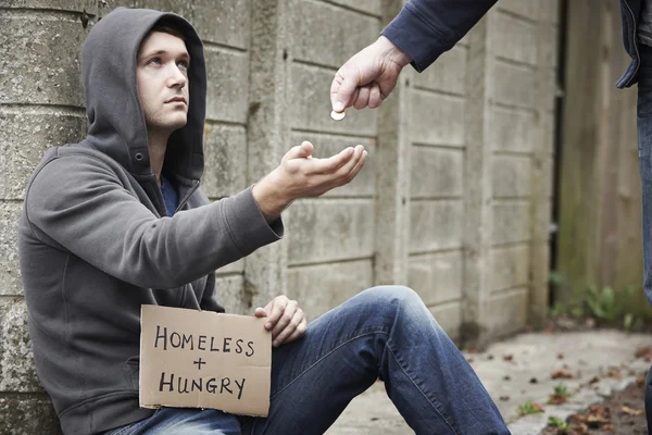 Человек, дающий деньги нищему на улице — стоковое фото