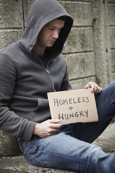Бездомный молодой человек, попрошайничающий на улице — стоковое фото