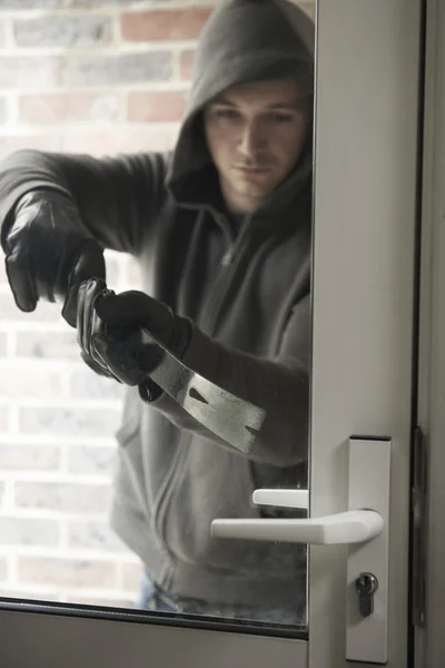 Innbruddstyv som bruker Crowbar til å bryte seg inn i huset – stockfoto