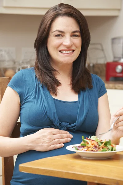 Mujer embarazada comiendo ensalada saludable en casa —  Fotos de Stock