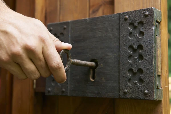 Hand vrida nyckeln i gamla gammaldags lås — Stockfoto