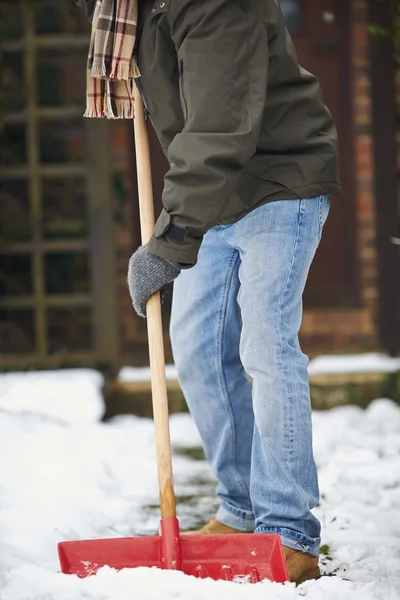 Primer plano del hombre despejando la nieve del camino —  Fotos de Stock