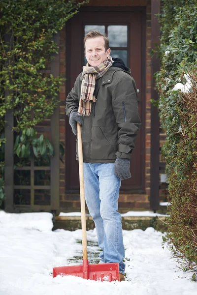 Hombre despejando nieve cubierto camino fuera de casa — Foto de Stock