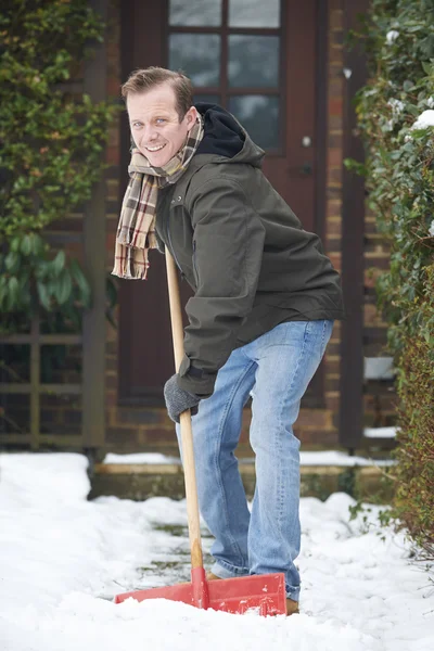 Hombre despejando nieve cubierto camino fuera de casa — Foto de Stock