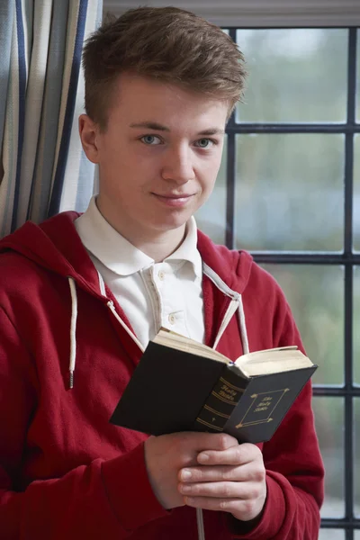 Teenager liest zu Hause Bibel — Stockfoto