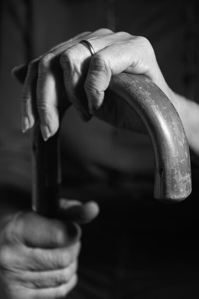 Black And White Image Of Senior Woman Holding Walking Stick