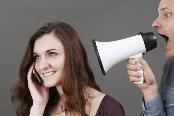 Frustrated Father Shouting At Teenage Daughter On Mobile Through Royalty Free Stock Photos