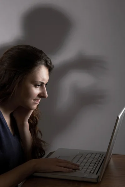 Teenage Girl Using Laptop With Menacing Shadow In Background — Stock Photo, Image