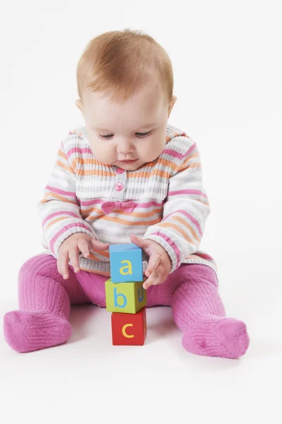 Estúdio tiro de menina jogando com blocos de alfabeto — Fotografia de Stock