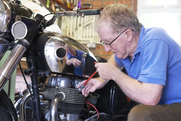 Homme âgé travaillant sur la moto vintage dans le garage — Photo