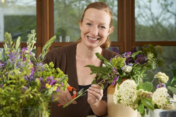 Florist arbetar med arrangemang i blomsteraffär — Stockfoto