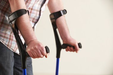 Close Up Of Man Using Crutches clipart