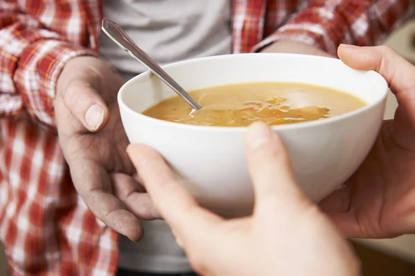 Homem sem-teto sendo enforcado tigela de sopa por voluntário — Fotografia de Stock