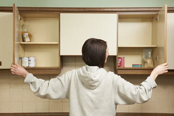 Mujer buscando comida vacía Armarios — Foto de Stock