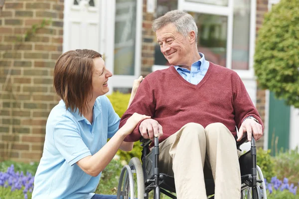 Cuidador con hombre mayor en silla de ruedas — Foto de Stock