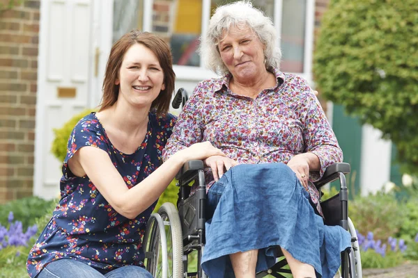 Fille adulte avec mère en fauteuil roulant — Photo