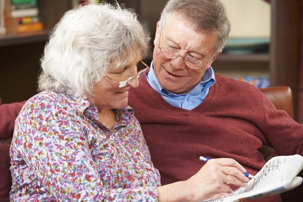 Senior Couple Doing Crossword Puzzle In Newspaper Together — Stock Photo, Image