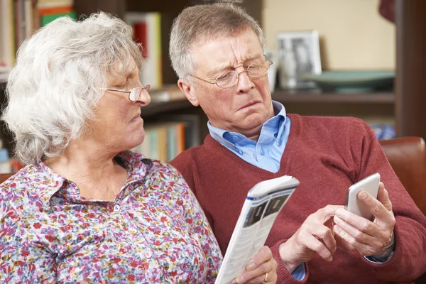 Confuzie cuplu în vârstă care încearcă să opereze telefonul mobil — Fotografie, imagine de stoc