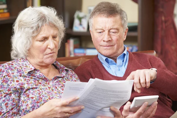 Беспокойная старшая пара рассматривает счета вместе — стоковое фото