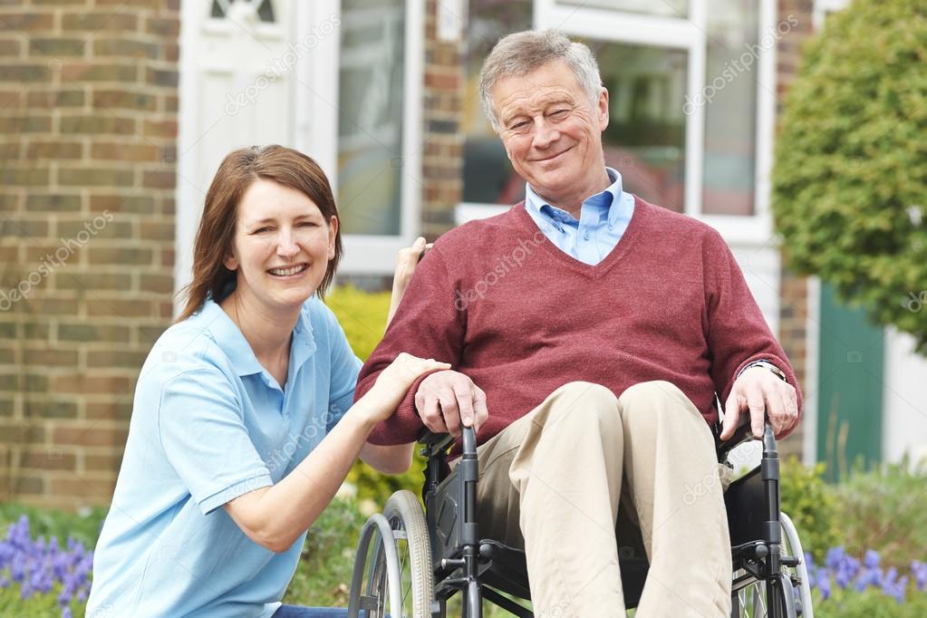 Carer With Senior Man In Wheelchair