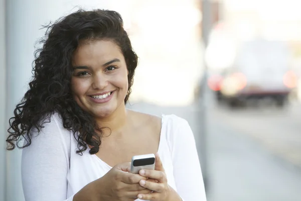 Ung kvinna med hjälp av mobiltelefon i Urban miljö — Stockfoto