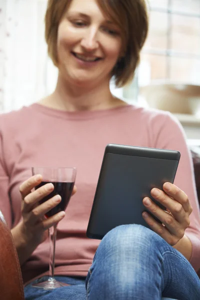 Жінка вдома читає електронну книгу Питне вино — стокове фото