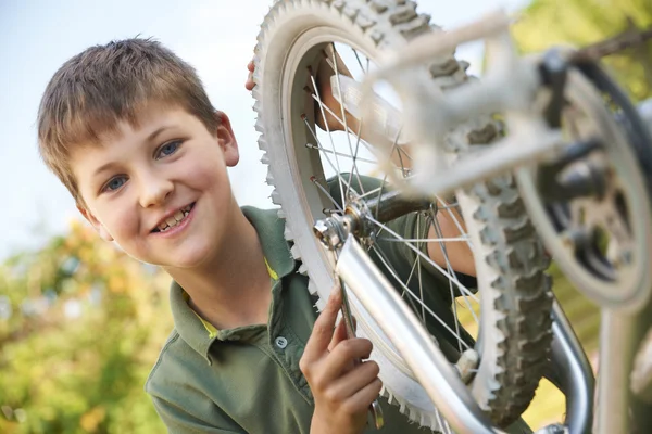 Хлопчик фіксує колесо велосипеда — стокове фото