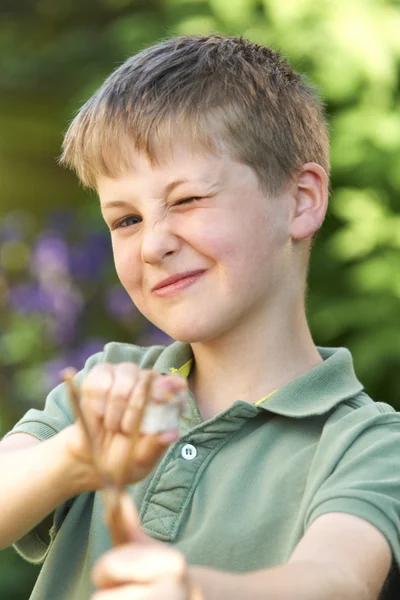 Junge zielte mit Schleuder in Garten — Stockfoto