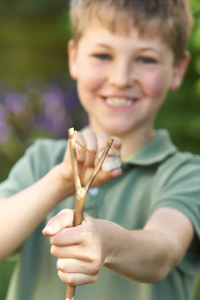 Pojke syftar slangbella i trädgården — Stockfoto