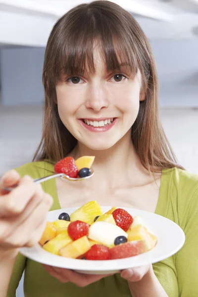 Giovane donna mangiare ciotola di frutta fresca — Foto Stock