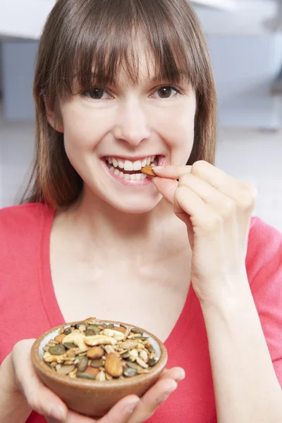 Mujer joven comiendo un tazón de semillas saludables — Foto de Stock