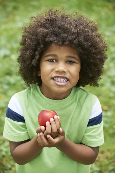 Kleine jongen eten Nectarine buitenshuis — Stockfoto