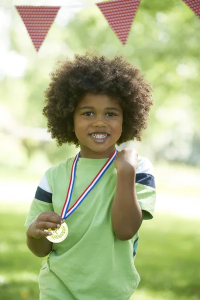 Menino jovem ganhando medalha no dia dos esportes — Fotografia de Stock