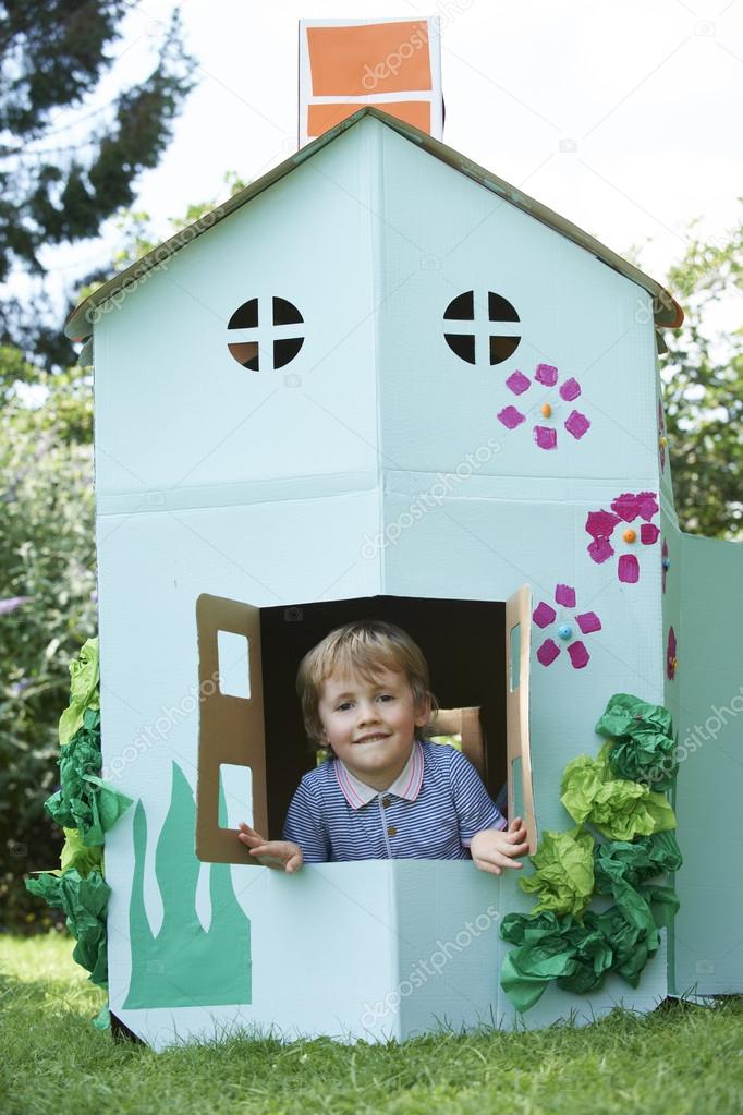 Young BoyPlaying In Home Made Cardboard House