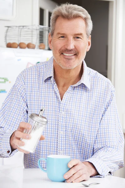 Mogen Man tillsätta socker till kopp kaffe — Stockfoto