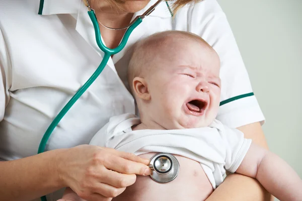 Медсестра слушает плач грудной клетки ребенка со стетоскопом — стоковое фото