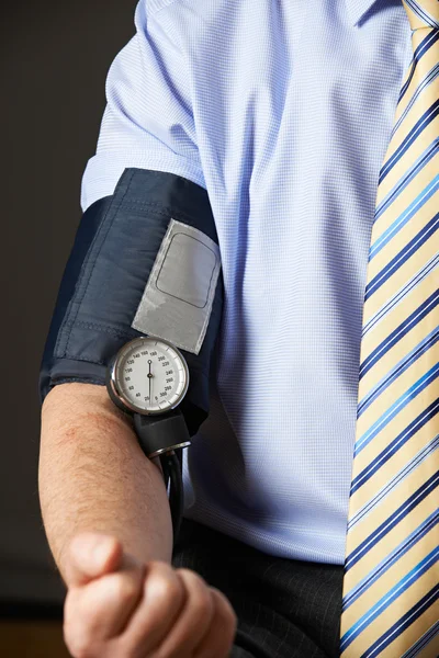 Close-up de empresário ter a pressão arterial verificada — Fotografia de Stock