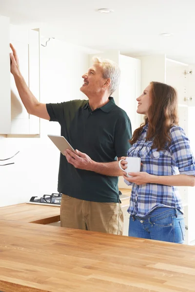 Frau mit Schreiner inspiziert neue Einbauküche — Stockfoto