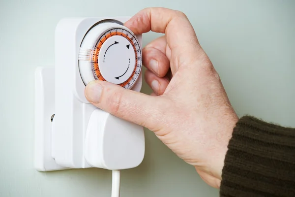 Man Timer op een stopcontact aan te passen — Stockfoto