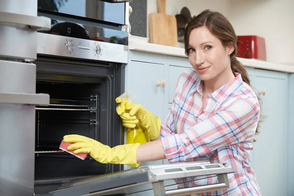 Retrato de mulher limpando forno em casa — Fotografia de Stock