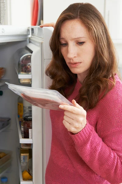 Donna preoccupata guardando carne preconfezionata — Foto Stock