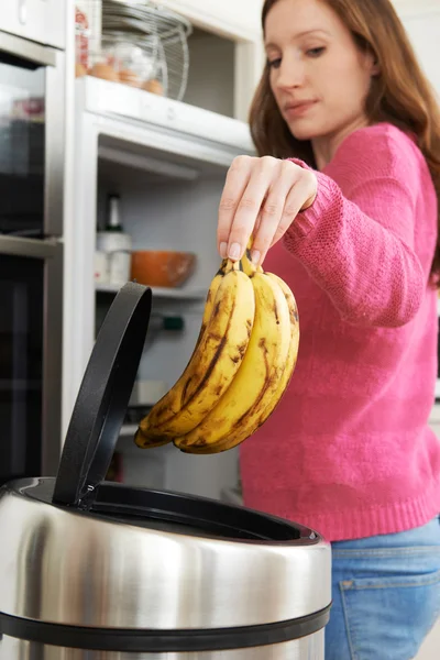 Donna che butta via cibo scaduto in frigorifero — Foto Stock