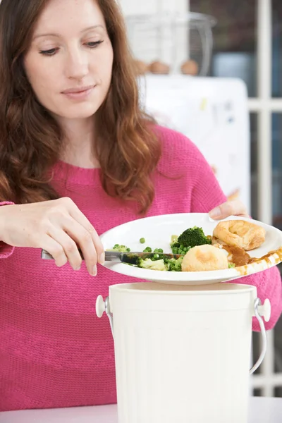 Donna raschiando avanzi di cibo nel cestino della spazzatura — Foto Stock