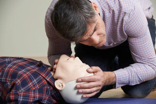 Man i första hjälpen klass Kontrollera luftvägarna på HLR Dummy — Stockfoto